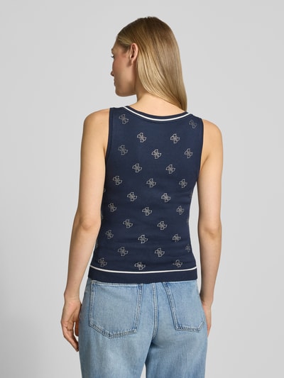 Männermodel trägt Slim Fit Top aus mieszanka wiskozy von Guess, obszycie z kamieni stras, detal z logo, imitacja dzianiny, okrągły dekolt, długość tyłu w rozmiarze S: 49 cm, granatowy kolor, prosty fason, Ganzkörperansicht Rückansicht.