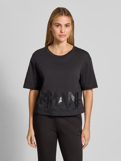 Vrouwenmodel draagt t-shirt met paillettenbesatz van Armani Exchange, puur katoen, los model, ronde hals, labelprint, ruglengte maat S 45 cm, geheel van voren