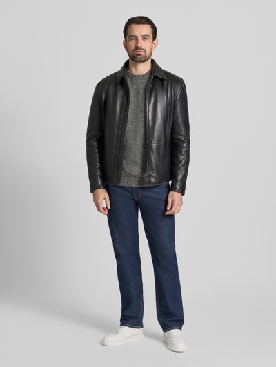 Männermodel trägt Loose Fit Strickpullover mit Woll-Anteil Modell 'BLASIMON' van Jack & Jones Premium in grijs, geribde boorden, ronde hals, materiaal-mix, rechte blauwe jeans en witte sneakers, heren knitwear, ganzkörperansicht von vorne.