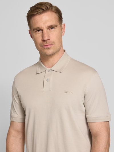 Männermodel trägt Regular Fit Poloshirt aus reiner Baumwolle Modell 'INTERLOCK' von BOSS Orange, unifarben, Nahaufnahme Oberkörper.
