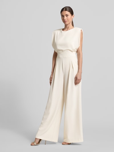 Kobiece model prezentuje Regular Fit Jumpsuit mit Rundhalsausschnitt od Rinascimento, kremowy odcień, bez rękawów, materiał elastyczny, krój regular fit, taliowany, kellerfalten, szerokie nogawki, długość całkowita w rozmiarze S: 150 cm, szerokość w rozmiarze S: 45 cm, długość wewnętrzna nogawki w rozmiarze S: 86 cm, tekstura gładka, widok całej sylwetki z przodu.