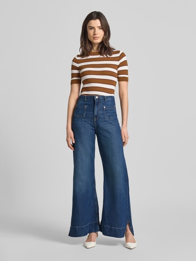 Frauenmodel trägt Flared Jeans aus Baumwoll-Mix Modell 'C_MARLENE' von BOSS Orange in Denim-Optik mit Label-Patch, Nieten und Seitenschlitz, Ganzkörperansicht von vorne.