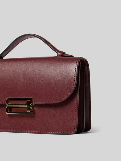 Produktfoto, Clutch aus Leder von Victoria Beckham in Dunkelrot mit goldfarbenem Verschluss, beschichtet, abnehmbarer Schulterriemen, Überschlag, Innentasche, zwei Hauptfächer, Breite 20 cm, Länge 12 cm, Tiefe 8 cm, glatte Textur, klare Kanten.