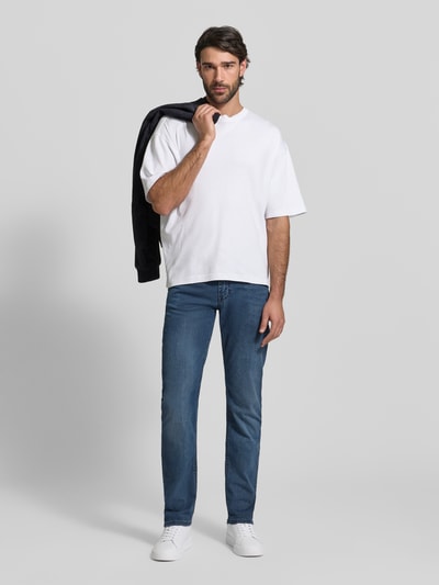 Männermodel trägt Straight Fit Jeans aus Baumwoll-Mix von MAC in Blau mit Kontrastnähten, 5-Pocket-Design, Ganzkörperansicht von vorne.