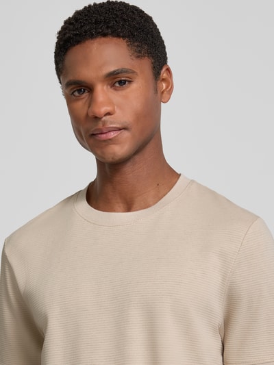 Männermodel trägt Regular Fit T-Shirt aus Baumwoll-Mix von s.Oliver RED LABEL in Beige mit feiner Struktur, Nahaufnahme Oberkörper.