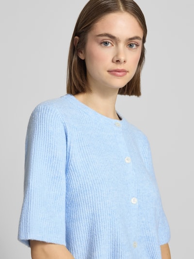 Frauenmodel trägt Regular Fit Strickjacke mit Woll-Anteil Modell 'SILLY' von Pieces, Optik: Unifarben, Materialverarbeitung: Rippstrick, Rundhals, Kurzarm, Verschluss: einreihige Knopfleiste, Nahaufnahme Oberkörper.