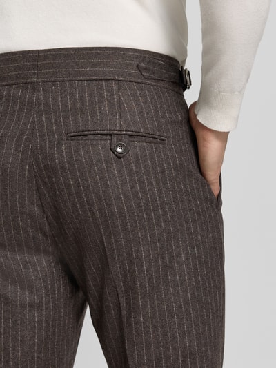 Frauenmodel trägt Straight Fit Hose aus Woll-Mix Modell 'Tense' von Tiger of Sweden, braun mit feinen Streifen, Detailaufnahme, Damen Hose Woll-Mix, Bügelfalten, Knopf- und Reißverschluss, Bundweite 48 cm, Innenbeinlänge 79 cm.