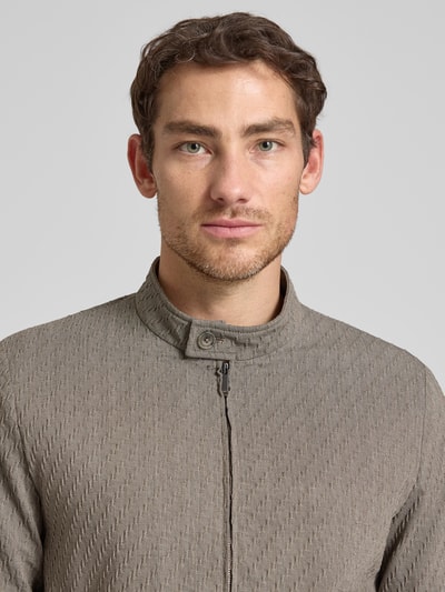 Männermodel trägt Jacke aus Schurwoll-Mix mit Zweiwege-Reißverschluss von Emporio Armani in Beige mit Strukturmuster, Nahaufnahme Oberkörper. Regular Fit, Stehkragen, Stretch-Anteil werden sichtbar.