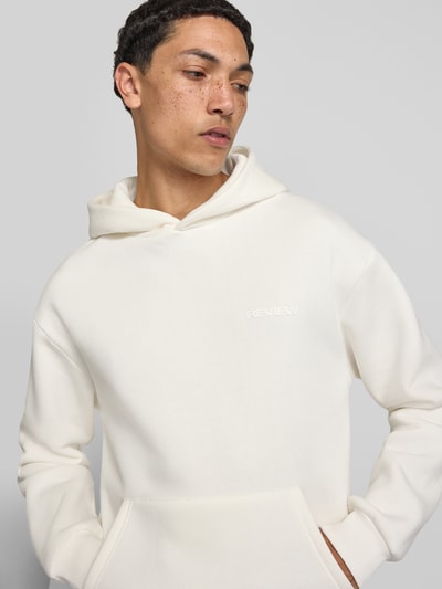 Männermodel trägt Regular Fit Hoodie mit Känguru-Tasche von REVIEW aus Baumwoll-Mix in Creme, dezente Struktur, Nahaufnahme Oberkörper. Rückenlänge bei Größe M: 70 cm, Ärmellänge bei Größe M: 62 cm.