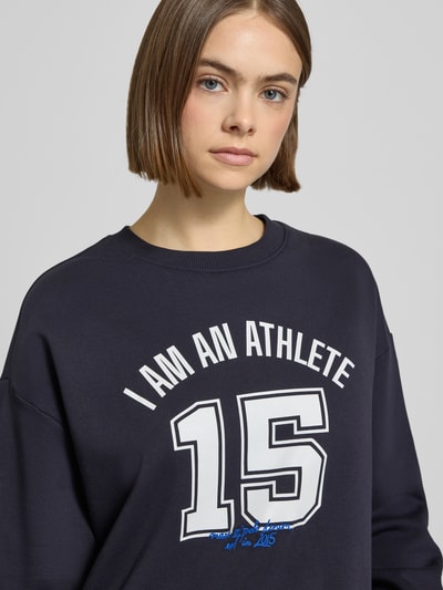 Frauenmodel trägt Relaxed Fit Sweatshirt aus reiner Baumwolle von Marc O'Polo Denim, Optik: Unifarben, Motiv-Print, Nahaufnahme Oberkörper.
