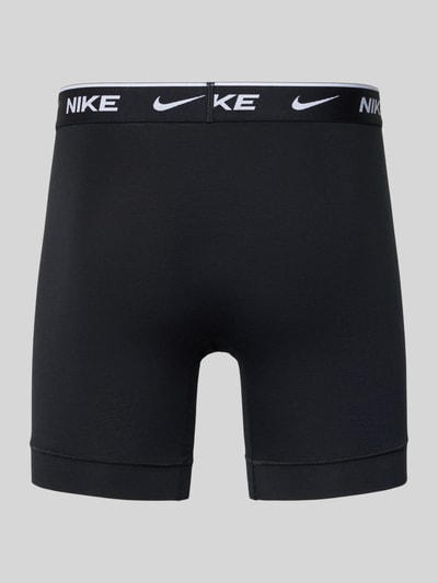 Produktfoto, zwarte Trunks met logo-schriftzug Modell 'E-DAY' van Nike, aansluitende fit, elastische tailleband, labelprint, grijze achtergrond