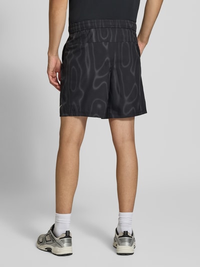 Männermodel trägt Regular Fit Sportshorts mit Dri-FIT-Technologie von Nike, schwarze Shorts mit Muster, Herren Sportshorts, Ganzkörperansicht Rückansicht.
