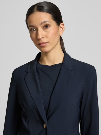 Kobieta modelka nosi Slim Fit Blazer mit Knopfverschluss von WHITE LABEL, mieszanka materiałów z dodatkiem streczu, krój slim fit, kołnierz z połami, zapięcie na guzik, wpuszczane kieszenie, długość tyłu w rozmiarze 36: 61 cm, szerokość w rozmiarze 36: 50 cm, długość rękawów w rozmiarze 36: 61 cm, granatowy kolor, gładka faktura, półzbliżenie na górną część ciała, widok z przodu