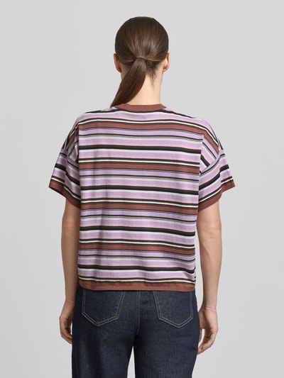 Kobiece model prezentuje t-shirt z obniżonymi ramionami Stefanel, kolorowe paski, czysta bawełna, prosty krój, długość tyłu 53 cm, długość rękawów 12 cm, widok całej sylwetki od tyłu.