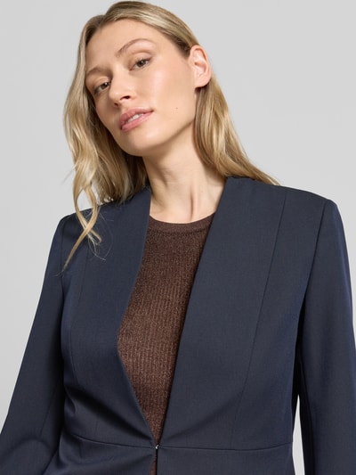 Frauenmodel trägt Slim Fit Blazer mit Hakenverschluss von Christian Berg Woman Selection aus dunkelblauem Material-Mix mit Viskose-Anteil, Nahaufnahme Oberkörper.