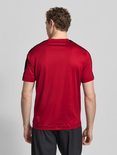 Männermodel trägt T-Shirt mit Label-Detail von Emporio Armani in Rot, Lyocell-Baumwoll-Mix, Regular-Fit, Rückenlänge 70 cm, Ganzkörperansicht Rückansicht.