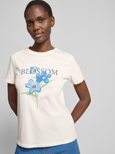 Frauenmodel trägt T-Shirt mit Motiv-Print und Rundhalsausschnitt von Jake*s Casual aus Reine Baumwolle, Regular-Fit, Rückenlänge 58 cm, Motiv in Blau und Grün auf hellem Stoff, Ganzkörperansicht von vorne.