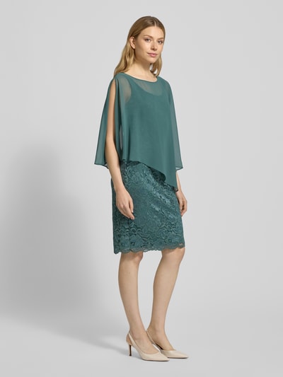 Frauenmodel trägt Knielanges Cocktailkleid im 2-in-1-Look von Vera Mont mit Material-Mix, Stretch-Anteil, Spitze, Gerader-Schnitt, Knielänge, Ganzkörperansicht von vorne.