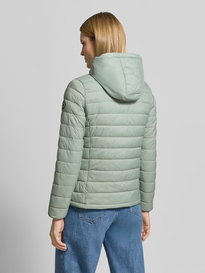 Vrouwenmodel draagt gewatteerd jack met capuchon Modell 'THELMA' van CARS JEANS in lichtgroen, regular fit, met ritssluiting en steekzakken, ruglengte 61 cm, schouderbreedte 39 cm, borstwijdte 50 cm, mouwlengte 62 cm, ganzkörperansicht rückansicht.