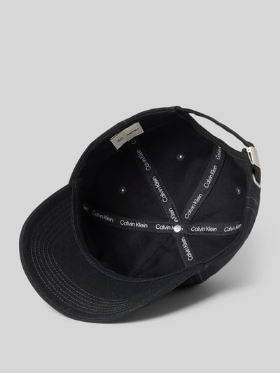 Produktfoto, schwarze Cap aus Baumwolle mit Logo von CK Calvin Klein, strukturierter Stoff, verstärkter Schirm, verstellbarer Riegel, Innenansicht