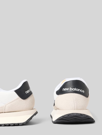 Produktfoto, Sneaker aus Leder mit Label-Details Modell '237' von New Balance in Weiß und Schwarz, beschichtetes Leder, abgerundete Form, profilierte Sohle, Schnürung, Absatzhöhe 3 cm, Schafthöhe 7 cm, Schaftweite 8 cm, für Damen