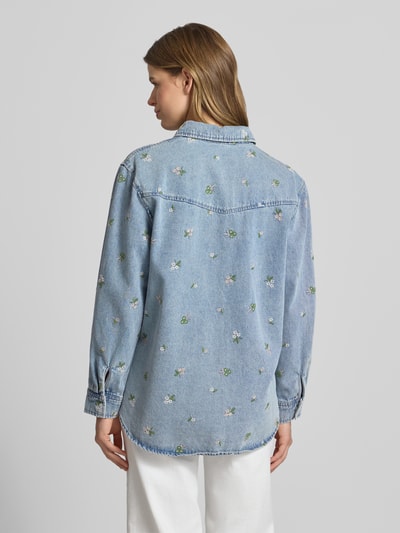 Kobiece modelka nosi bluzkę jeansową Relaxed Fit Jeansbluse aus reiner Baumwolle Modell 'VERA' od Only z haftami kwiatowymi, materiał bawełna, tył, całe ciało, widok z tyłu.