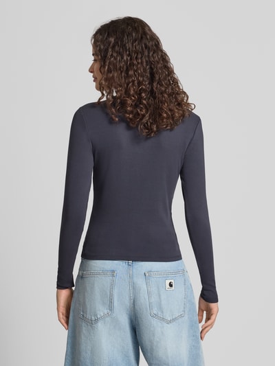 Frauenmodel trägt Regular Fit Langarmshirt aus Baumwoll-Mix Modell 'RILEY' von ONLY, dunkelblau, kombiniert mit hellblauer Jeans, Ganzkörperansicht Rückansicht. Damen Langarmshirt von ONLY.