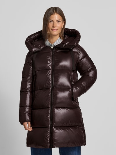 Frauenmodel trägt Steppmantel mit Kapuze und Label-Patch Modell 'ISABEL' von Save The Duck, glänzende dunkelbraune Farbe, gesteppt, Zweiwege-Reißverschluss, seitliche Reißverschlusstaschen, gerader Schnitt, Ganzkörperansicht von vorne.