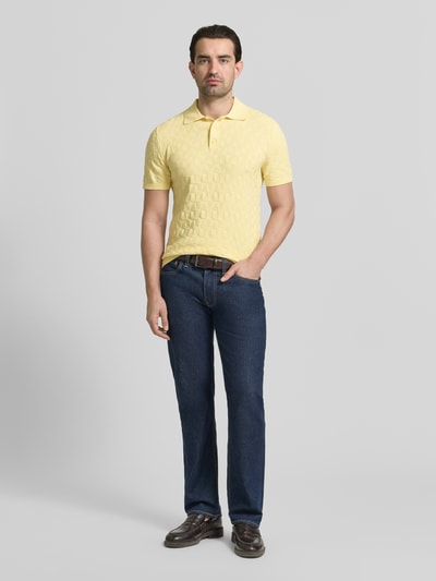 Männermodel trägt Regular Fit Poloshirt mit Strukturmuster von MCNEAL in Gelb, reine Baumwolle, Strick-Optik, Ganzkörperansicht von vorne.