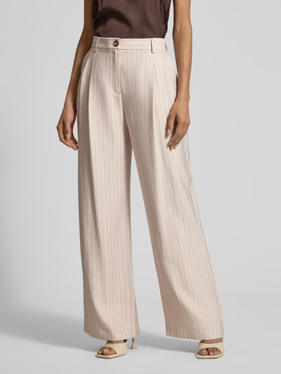 Modelka nosi Wide Leg Hose mit Gesäßtaschen von Jake*s Collection, beżowe spodnie z szerokimi nogawkami, zakładkami, kieszeniami z tyłu, zapięciem na guzik i zamek błyskawiczny, szerokość w rozmiarze 38: 39 cm, długość wewnętrzna nogawki w rozmiarze 38: 79 cm, tekstura gładka w pionowe prążki, widok całej sylwetki z przodu