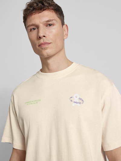 Männermodel trägt Relaxed Fit T-Shirt aus reiner Bio-Baumwolle Modell 'MAARKOS' von Armedangels, unifarben, Logo Print, Nahaufnahme Oberkörper