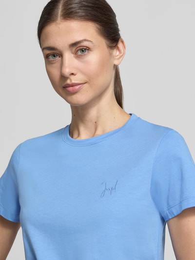 Frauenmodel trägt T-Shirt mit Rundhalsausschnitt und Motiv-Stitching von JOOP!, reine Baumwolle, gerader Schnitt, Nahaufnahme Oberkörper.