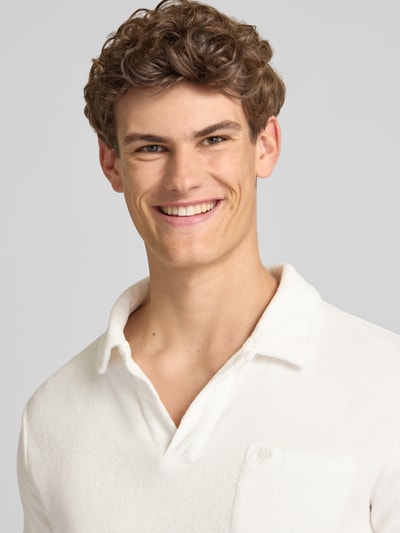 Männermodel trägt Slim Fit Poloshirt aus Frottee von Superdry in Weiß, Reine Baumwolle, Kurzärmelig, Nahaufnahme Oberkörper.