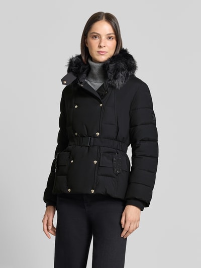 Frauenmodel trägt schwarze Jacke mit Kunstfellbesatz, Ziersteinen und Tailliengurt, Modell 'IMBOTTITO' von Liu Jo, Ganzkörperansicht von vorne.