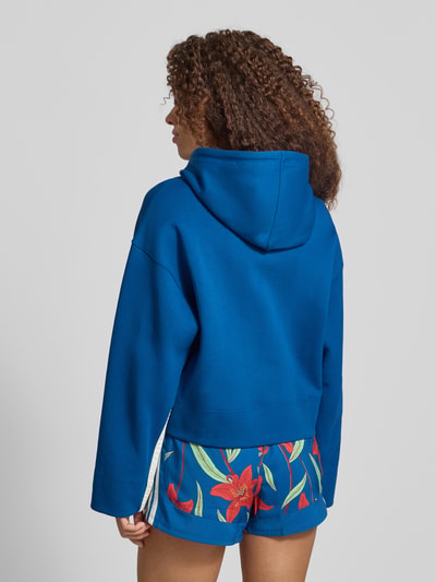 Frauenmodel trägt Regular Fit Hoodie aus baumwoll-mix von adidas Sportswear, efekt: jednolity kolor, nadruk z motywem, kaptur z tunel, długi rękaw, zakończenia rękawów i wykończenie: prążkowane, wykończenie materiału: dzianina dresowa, mieszanka bawełny, Ganzkörperansicht Rückansicht