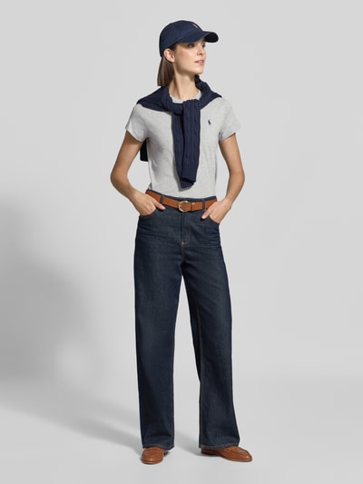 Vrouwenmodel draagt Regular Fit t-shirt van puur katoen van Polo Ralph Lauren in lichtgrijs met klein logo, donkerblauwe trui, jeans, bruine riem, tennisschoenen, dames t-shirt van Polo Ralph Lauren, volledig lichaamsaanzicht van voren