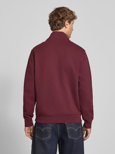 Männermodel trägt Regular Fit Pullover aus reiner Baumwolle von Levi's® in Dunkelrot, glatte Textur, Ganzkörperansicht Rückansicht.