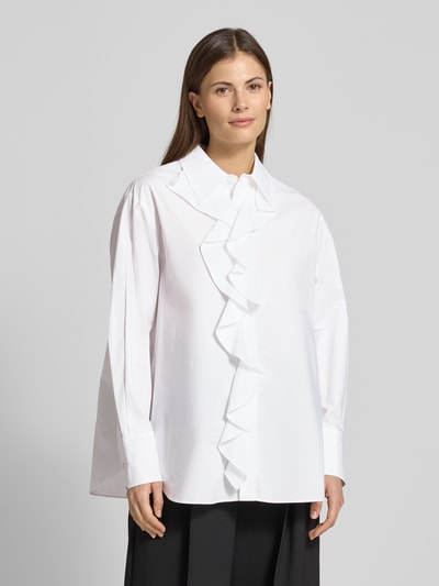 Frauenmodel trägt weiße Regular Fit Bluse mit Volants Modell 'FALESIA' von Marella, reine Baumwolle, Hemdblusenkragen, Ganzkörperansicht von vorne.