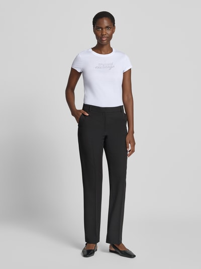 Frauenmodel trägt T-Shirt mit Ziersteinbesatz und Rundhalsausschnitt von Armani Exchange, weiße Baumwolle, Slim Fit, Logo, Ganzkörperansicht von vorne.