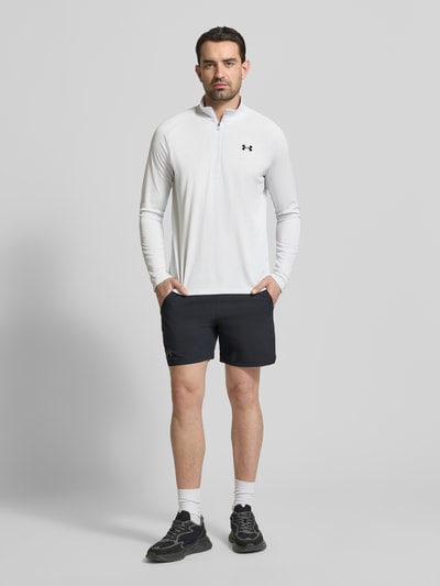 Męski model nosi Sweatshirt mit kurzem Reißverschluss und Logo-Print von Under Armour, biały kolor, prosty krój, stójka, nadruk z logo, długość tyłu w rozmiarze m: 74 cm, długość rękawów: 64 cm, całkowity widok z przodu