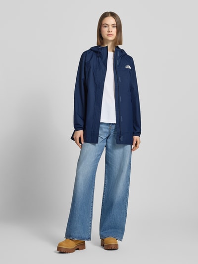 Modelka prezentuje Regular Fit Parka mit Logo-Print Modell 'Antora' od The North Face, kolor granatowy, kaptur, kieszenie, kobiecy krój regular fit, długość tyłu w rozmiarze S: 74 cm, szerokość ramion w rozmiarze S: 39 cm, szerokość klatki piersiowej w rozmiarze S: 50 cm, długość rękawa w rozmiarze S: 64 cm, widok całej sylwetki z przodu.