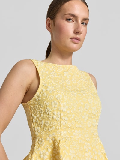 Vrouwenmodel draagt Shaped Fit Schößchen-Top met bloemmotief model 'FIONA' van Vero Moda, structuur, boothals, mouwloos, detailopname bovenlichaam.