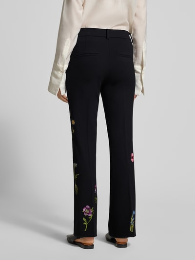 Frauenmodel trägt schwarze Stoffhose mit floralen Stickereien, geradem Schnitt und französischen Eingrifftaschen, Modell 'FRANCOISE' von Cambio, Ganzkörperansicht Rückansicht, Viskose-Mix mit Stretch, Bundfalten, Gesäßtaschen.