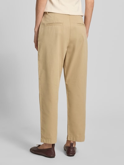 Frauenmodel trägt Chino mit Paspeltaschen am Gesäß von Jake*s Casual in Beige, Relaxed-Fit, verkürzte Passform, Ganzkörperansicht Rückansicht. Bundweite bei Größe 36: 37 cm, Innenbeinlänge bei Größe 36: 68 cm, mit Eingrifftaschen und markanten Texturen.