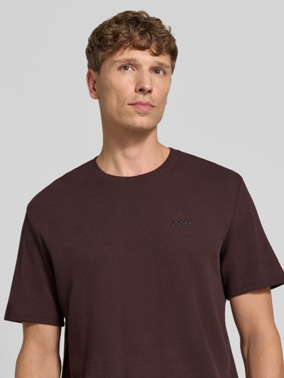 Männermodel trägt Regular Fit T-Shirt aus Baumwoll-Mix Modell 'WAFFLE' von BOSS, braune Farbe, dezente Waffelstruktur, Nahaufnahme Oberkörper, Herren T-Shirt von BOSS.
