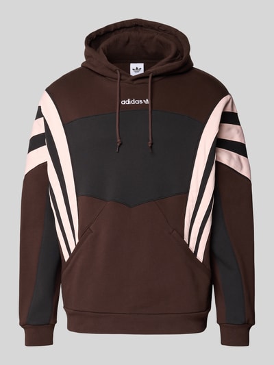 Produktfoto, Hoodie mit Kapuze von adidas Originals in Braun und Schwarz mit beigen Streifen, Känguru-Tasche, Label-Stitching, Gerippte-Abschlüsse, Lockere-Schnitt, Tunnelzug, Rückenlänge 71 cm, Ärmellänge 66 cm.