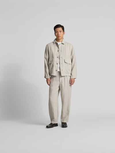 Männermodel trägt Straight Fit Leinenhose von Closed in Beige mit elastischem Bund, Seitentaschen und Gesäßtaschen, Ganzkörperansicht von vorne.