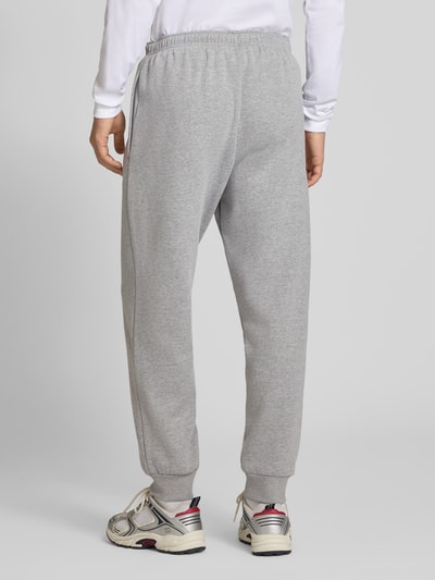 Männermodel trägt Relaxed Fit Sweatpants aus katoenmix Model 'EVOLUTION' van The North Face, grijs met elastische band en zij-steekzakken, Heren sweatpants, binnenbeenlengte maat M 75 cm, Ganzkörperansicht Rückansicht.