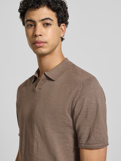 Männermodel trägt Slim Fit Poloshirt in Strick-Optik Modell 'Kane' von JACK & JONES, Reine Baumwolle, kurzärmelig, Polokragen, Nahaufnahme Oberkörper.
