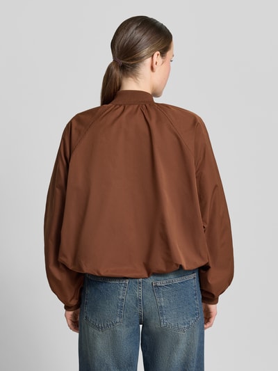 Frauenmodel trägt Blouson mit elastischen Ärmelabschlüssen und Reißverschluss von Zero, Loose-Fit, braune glatte Oberfläche, Ganzkörperansicht Rückansicht. Rückenlänge bei Größe 36: 52 cm, Schulterbreite: 40 cm, Brustweite: 50 cm, Ärmellänge: 55 cm, Raglanärmel.